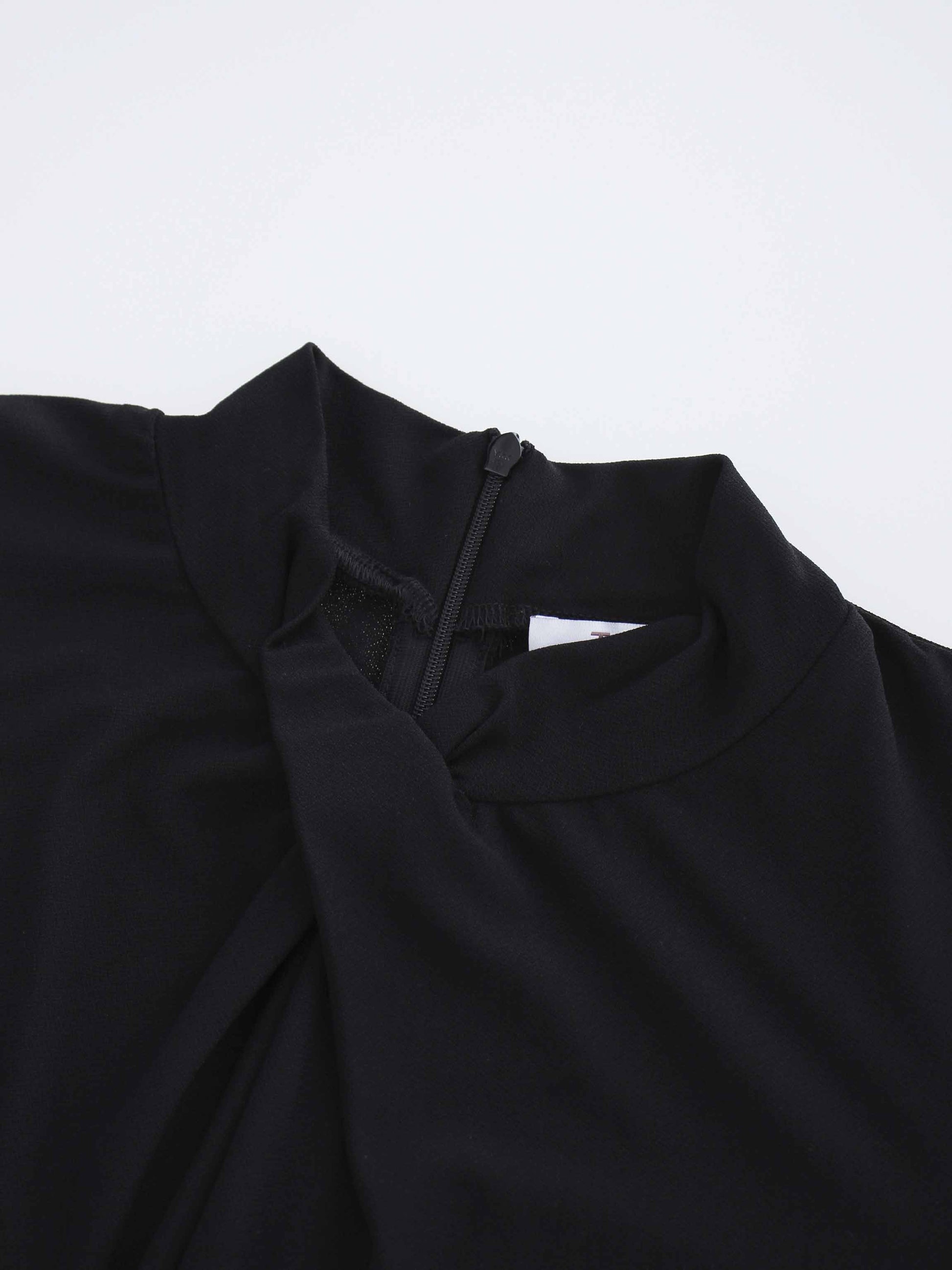 Close-up of a black garment with a high neckline on a light gray background