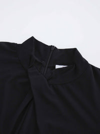 Close-up of a black garment with a high neckline on a light gray background
