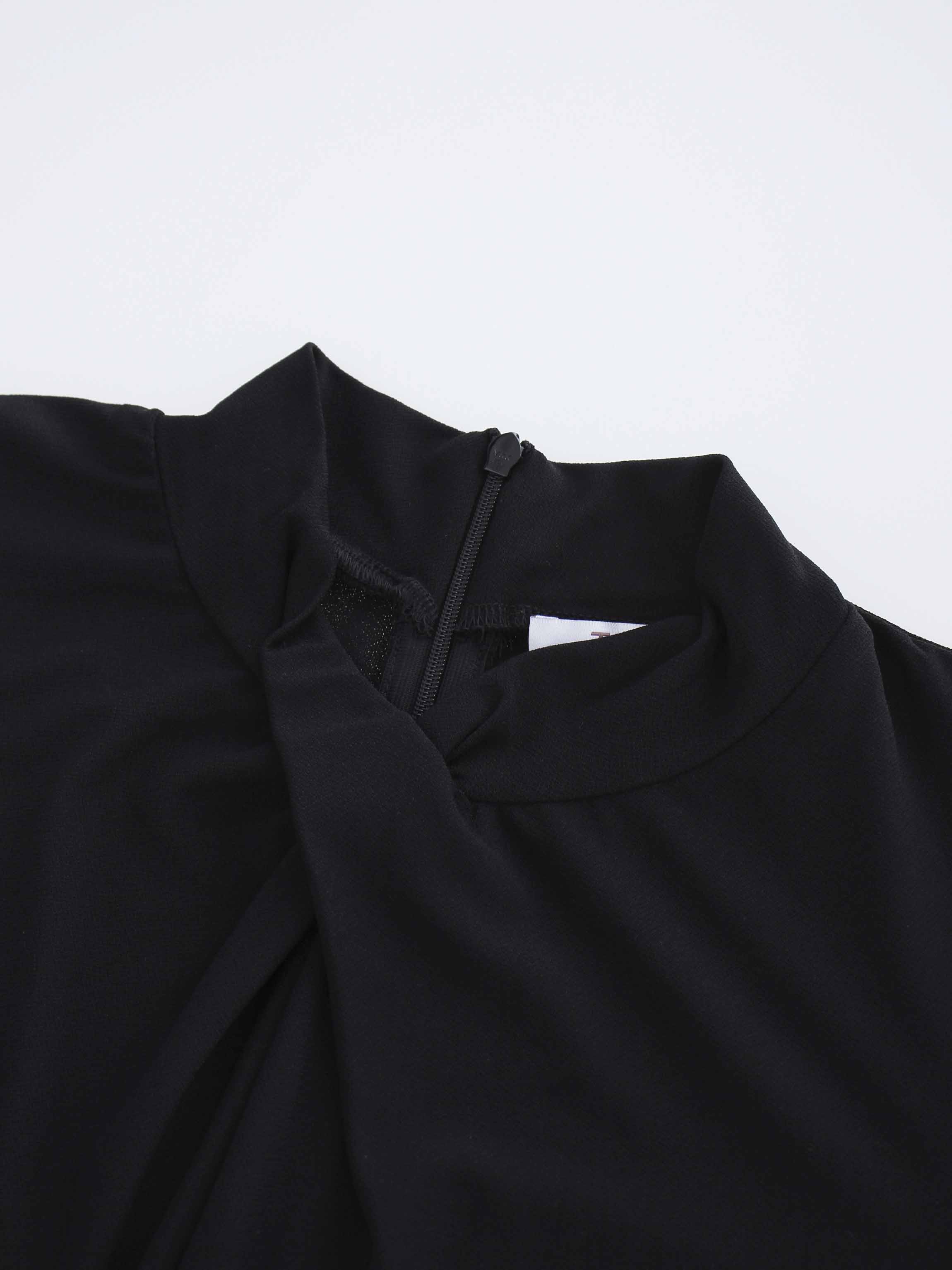 Close-up of a black garment with a high neckline on a light gray background