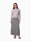 Woman wearing a light gray sweater and long skirt on a white background